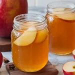 Apple Pie Moonshine recipe featuring apples, cinnamon sticks, sugar, nutmeg, and liquor the perfect homemade moonshine.
