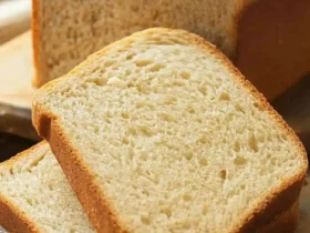 Low calorie bread recipe with sliced homemade bread on a wooden board.