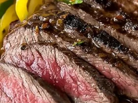 Sous vide flank steak sliced and served on a wooden cutting board